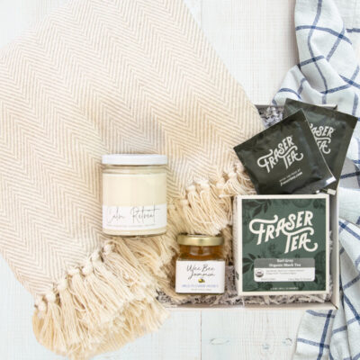 Unboxed employee gift bundle consisting of a blanket, various teas and honey .